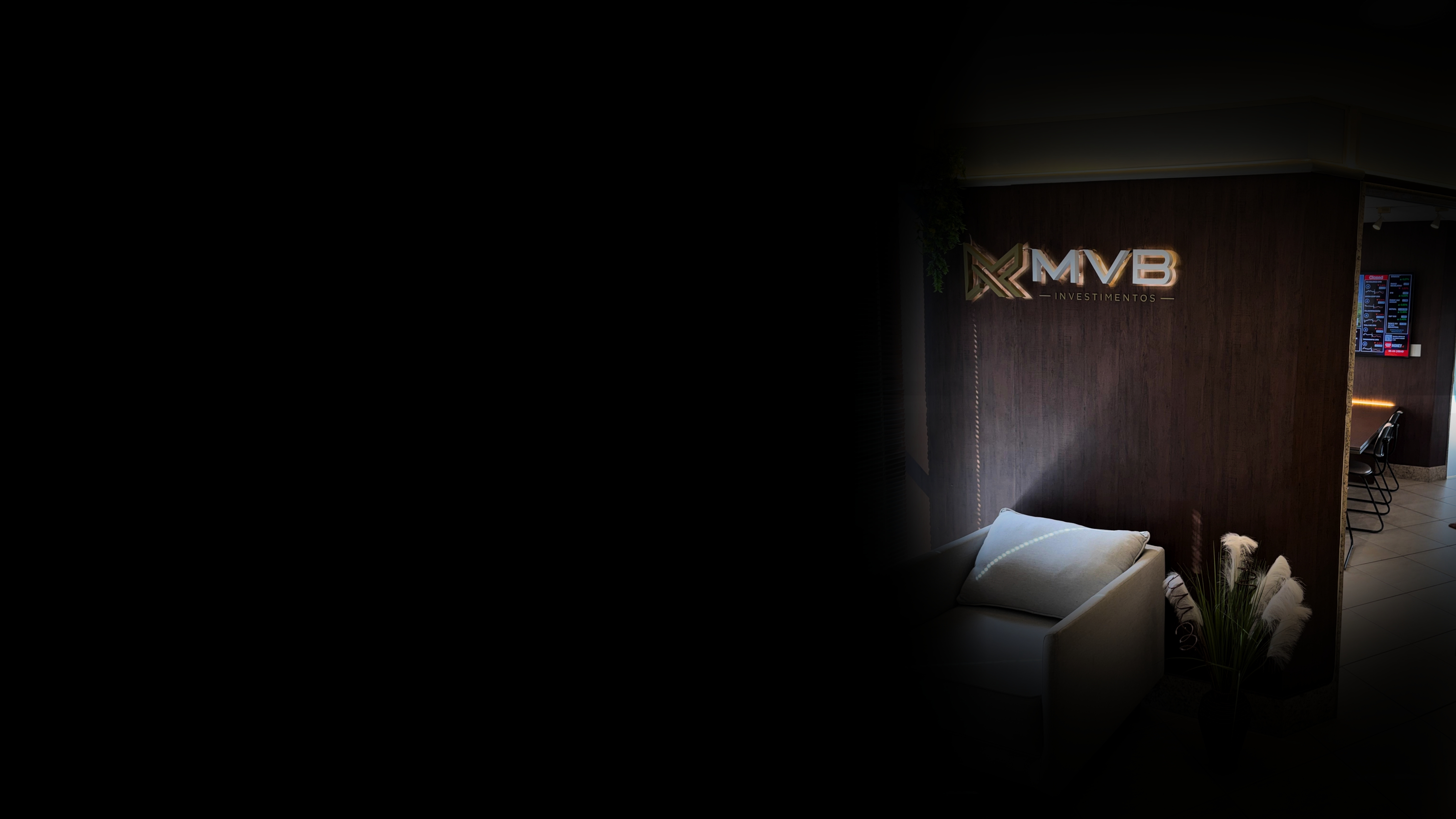 Escritório MVB Investimentos — sofá e marca no ambiente